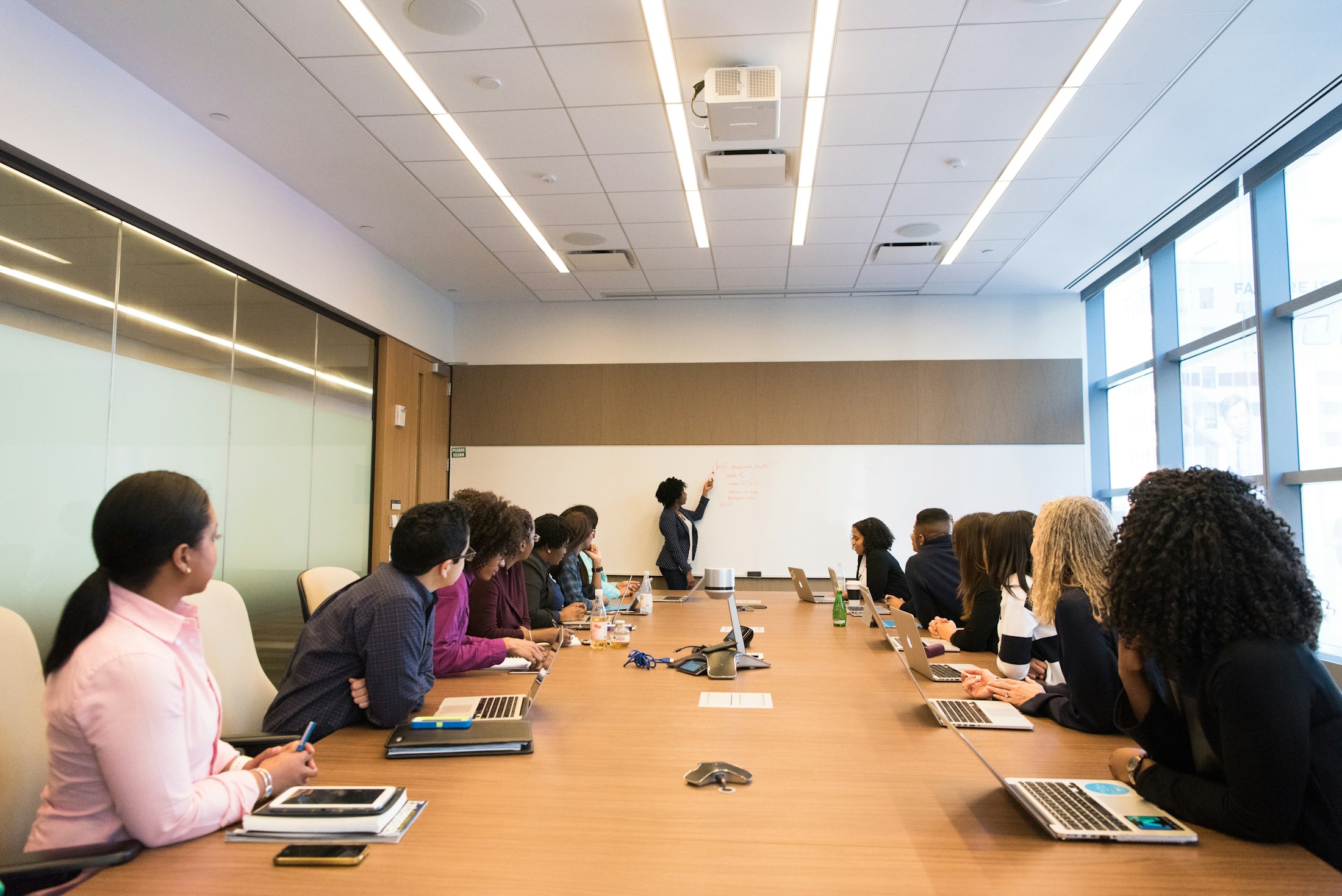 Professional team meeting with a presenter at the front of the room.